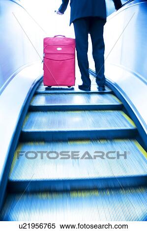 Stock Photography - Businessman travelling up an escalator. Fotosearch