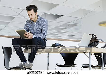 Picture - Businessman using digital tablet in office. Fotosearch