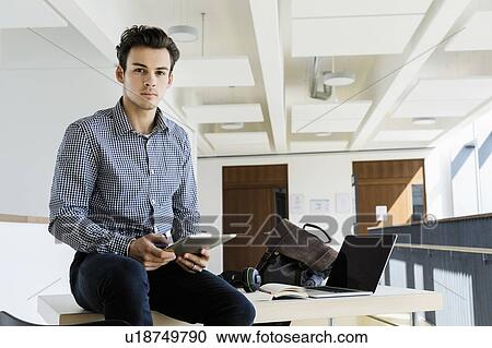 Stock Image - Businessman using digital tablet in office. Fotosearch