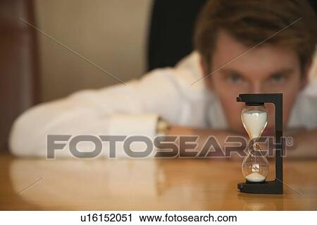 Businessman watching sand timer View Large Photo Image Stock Image - Businessman watching sand timer. Fotosearch