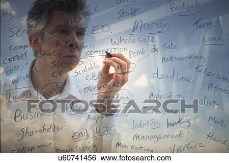 Businessman writing business words onto glass View Large Photo Image Stock Photograph - Businessman writing business words onto glass. Fotosearch