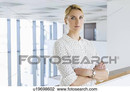 Businesswoman taking break in office corridor View Large Photo Image Stock Image - Businesswoman taking break in office corridor. Fotosearch