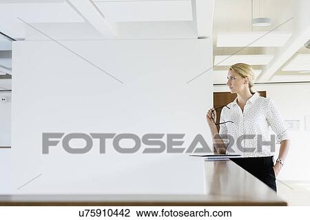 Businesswoman taking break in office corridor View Large Photo Image Stock Image - Businesswoman taking break in office corridor. Fotosearch