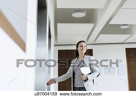Businesswoman with digital tablet pressing button of elevator View Large Photo Image Stock Photo - Businesswoman with digital tablet pressing button of elevator. Fotosearch