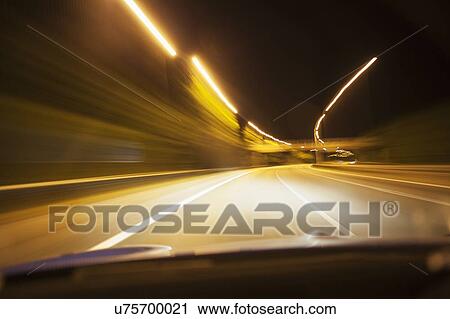 Stock Image - Car driving on road at night. Fotosearch