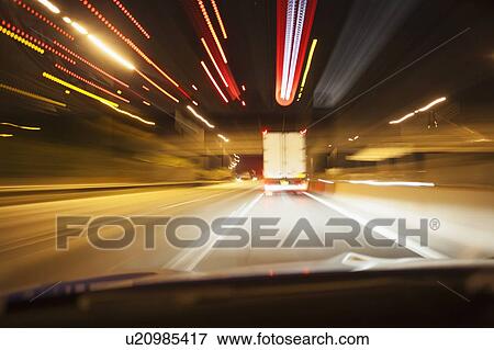 Stock Photo - Car driving on road at night. Fotosearch