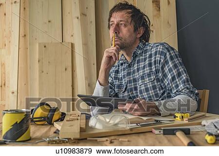Stock Photo - Carpenter using digital tablet. Fotosearch