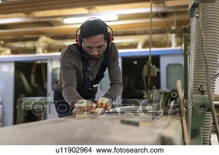 Picture - Carpenter working in factory. Fotosearch