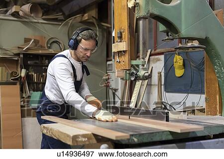 Stock Photo - Carpenter working in factory. Fotosearch