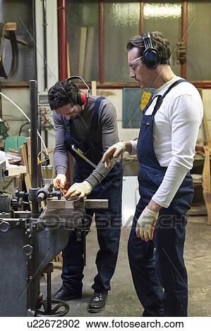 Stock Image - Carpenters working in factory. Fotosearch