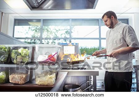Stock Photo - Chef making meal in development kitchen in food factory. Fotosearch