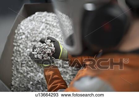 Close up of worker holding titanium sample in crushing plant in titanium recycling plant View Large Photo Image Stock Image - Close up of worker holding titanium sample in crushing plant in titanium recycling plant. Fotosearch