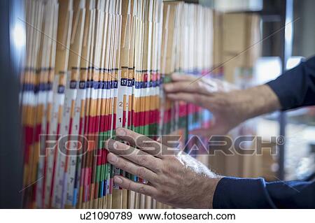 Close up of worker selecting job bags in print factory View Large Photo Image Stock Photo - Close up of worker selecting job bags in print factory. Fotosearch