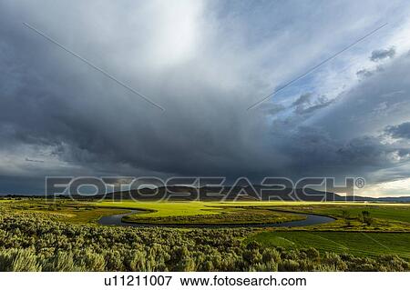 Cloudscape over river through fields in Picabo, Idaho, USA View Large Photo Image Stock Photo - Cloudscape over river through fields in Picabo, Idaho, USA. Fotosearch