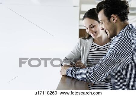 Colleagues using smartphone in office corridor View Large Photo Image Stock Image - Colleagues using smartphone in office corridor. Fotosearch