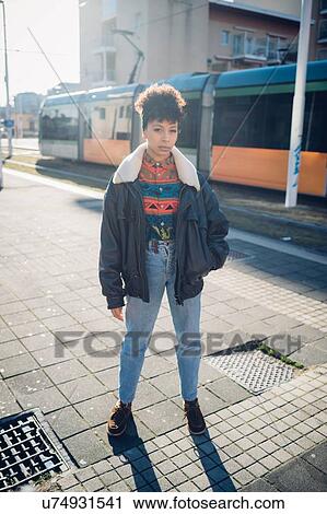 Cool young woman on sunlit urban sidewalk, portrait View Large Photo Image Stock Image - Cool young woman on sunlit urban sidewalk, portrait. Fotosearch