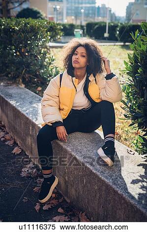 Cool young woman sitting on urban wall, portrait View Large Photo Image Stock Photography - Cool young woman sitting on urban wall, portrait. Fotosearch