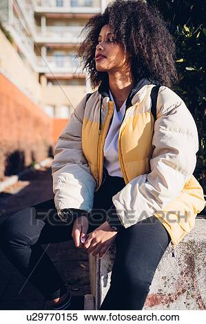 Cool young woman sitting on urban wall View Large Photo Image Stock Photography - Cool young woman sitting on urban wall. Fotosearch