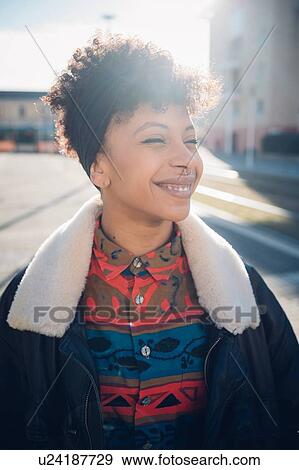 Cool young woman with nose piercing on sunlit urban sidewalk, portrait View Large Photo Image Stock Photo - Cool young woman with nose piercing on sunlit urban sidewalk, portrait. Fotosearch