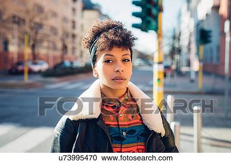 Stock Image - Cool young woman with pierced nose on city street, portrait. Fotosearch