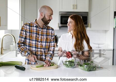 Couple chopping vegetables in kitchen View Large Photo Image Picture - Couple chopping vegetables in kitchen. Fotosearch