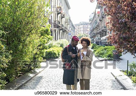 Couple enjoying ice-cream on street, Milan, Italy View Large Photo Image Stock Photo - Couple enjoying ice-cream on street, Milan, Italy. Fotosearch