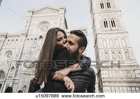 Stock Photo - Couple playing piggyback ride and kissing, Santa Maria del Fiore, Firenze, Toscana, Italy. Fotosearch