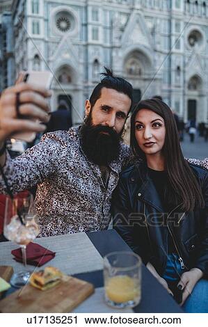 Stock Image - Couple taking selfie in cafe, Santa Maria del Fiore, Firenze, Toscana, Italy. Fotosearch