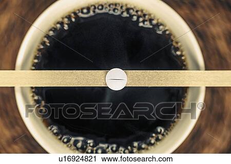 Stock Image - Cup of black coffee and caffeine supplement pill. Fotosearch