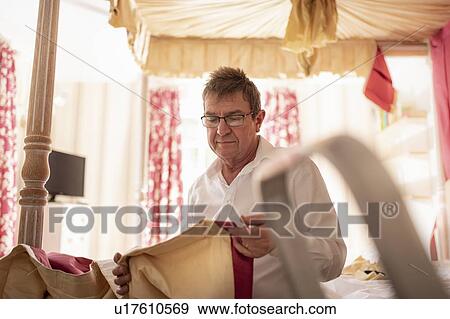 Curtain fitter inspecting material View Large Photo Image Stock Photo - Curtain fitter inspecting material. Fotosearch