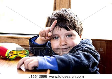 Stock Photograph - Cute boy smiling and pointing finger. Fotosearch