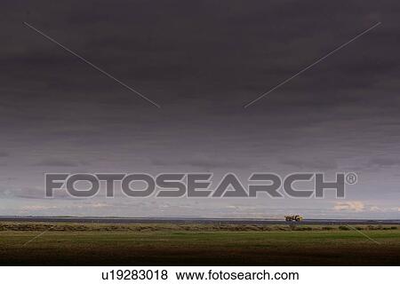 Stock Photo - Dark coastal landscape with distant truck, Selfoss, Arnessysla, Iceland. Fotosearch