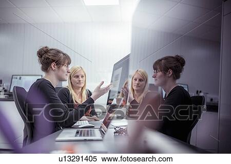 Stock Photography - Designers discussing packaging design work in print factory. Fotosearch