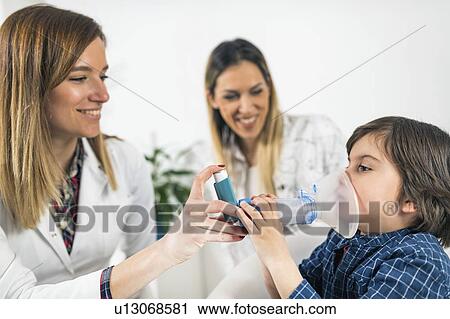 Stock Image - Doctor helping little boy with inhaler. Fotosearch