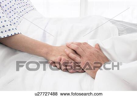 Stock Photo - Doctor holding patient's hand. Fotosearch