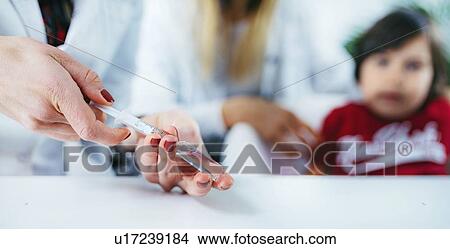 Picture - Doctor preparing a vaccine. Fotosearch