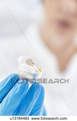 Doctor's hand in a glove holding graduated cup with pills View Large Photo Image Stock Image - Doctor's hand in a glove holding graduated cup with pills. Fotosearch