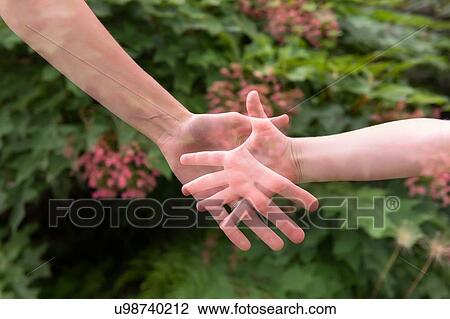 Stock Image - Double exposure of mother and daughter's hands. Fotosearch