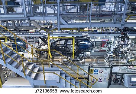 Stock Photo - Engine assembling into car body in car factory. Fotosearch