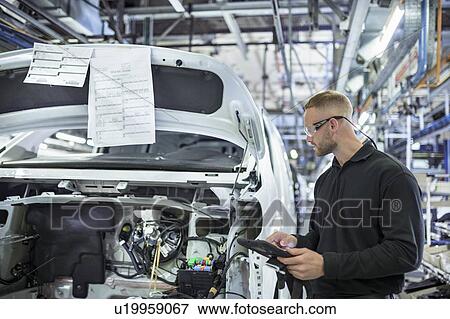 Stock Photo - Engineer with digital tablet on production line in car factory. Fotosearch