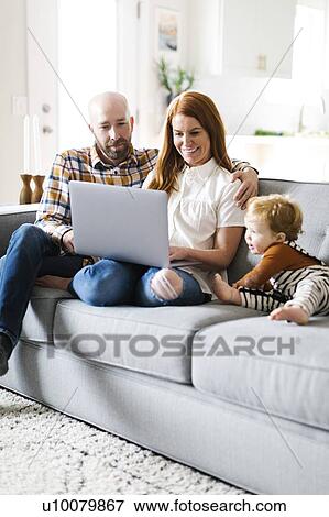 Family using laptop on sofa View Large Photo Image Stock Photo - Family using laptop on sofa. Fotosearch