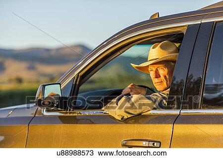 Farmer wearing cowboy hat driving SUV View Large Photo Image Stock Image - Farmer wearing cowboy hat driving SUV. Fotosearch