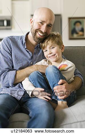Father and son smiling on sofa View Large Photo Image Stock Image - Father and son smiling on sofa. Fotosearch