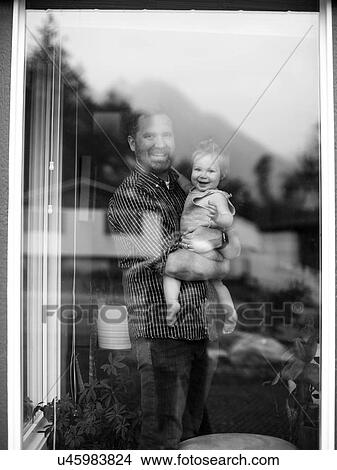 Father holding his daughter behind window View Large Photo Image Picture - Father holding his daughter behind window. Fotosearch