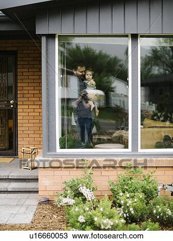 Father holding his daughter behind window of house View Large Photo Image Stock Image - Father holding his daughter behind window of house. Fotosearch