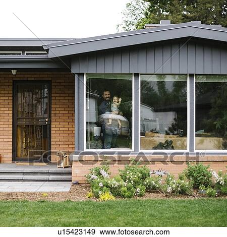 Father holding his daughter behind window of house View Large Photo Image Stock Photo - Father holding his daughter behind window of house. Fotosearch