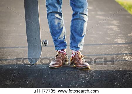 Feet of man with skateboard on footpath View Large Photo Image Stock Photography - Feet of man with skateboard on footpath. Fotosearch