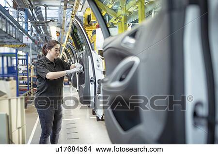 Female apprentice engineer assembling car doors in car factory View Large Photo Image Picture - Female apprentice engineer assembling car doors in car factory. Fotosearch