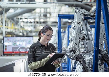 Female apprentice engineer using digital tablet to inspect parts in car factory View Large Photo Image Stock Photography - Female apprentice engineer using digital tablet to inspect parts in car factory. Fotosearch