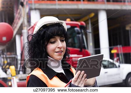 Female surveyor looking at digital tablet on construction site View Large Photo Image Stock Photography - Female surveyor looking at digital tablet on construction site. Fotosearch